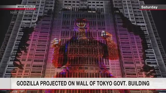 Изображение популярного киномонстра Годзиллы проецируется на стену здания Токийской столичной администрации