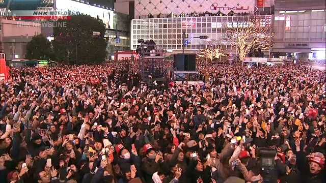 Толпы собравшихся на знаменитом перекрестке у станции Сибуя в центре Токио отсчитали последние минуты до Нового года